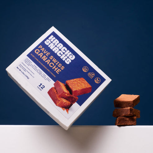 A box of Krack’d Snacks Pave Swiss Ganache, featuring rich chocolate squares stacked with a smooth ganache filling.